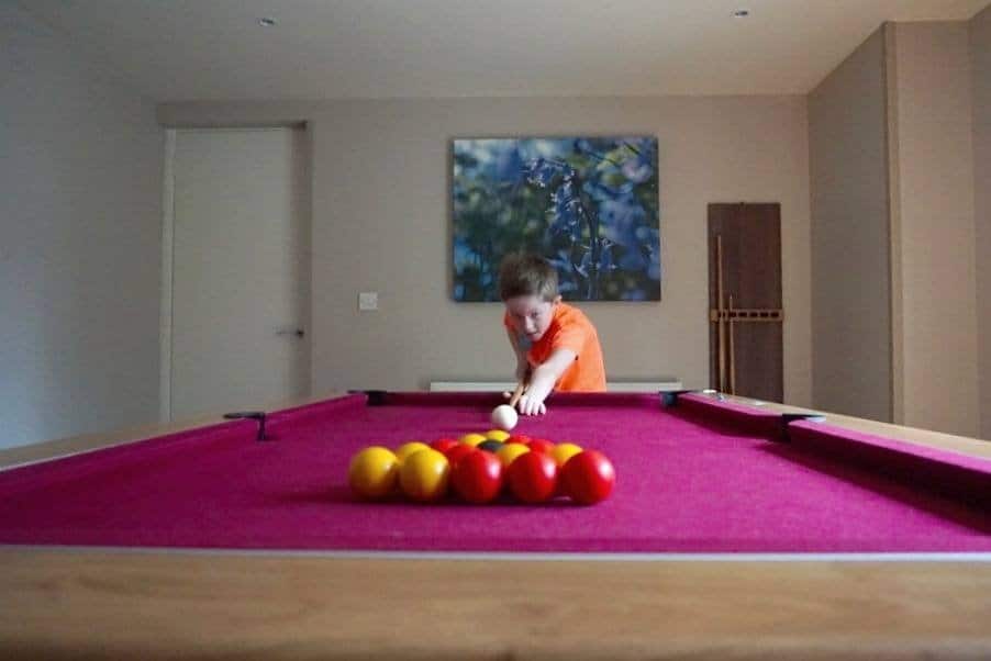 the games room has a pool table, separate patio area, large tv and xbox