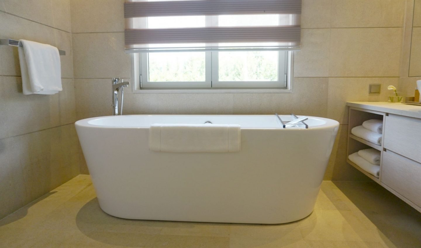 The large bathroom with a bathtub and double shower. 