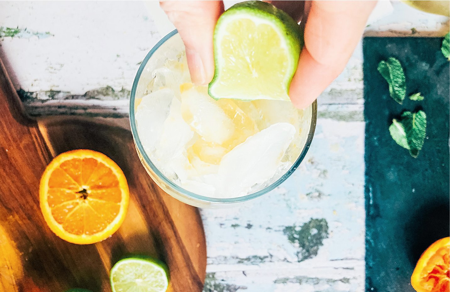 Add the orange, lime and ice to a glass