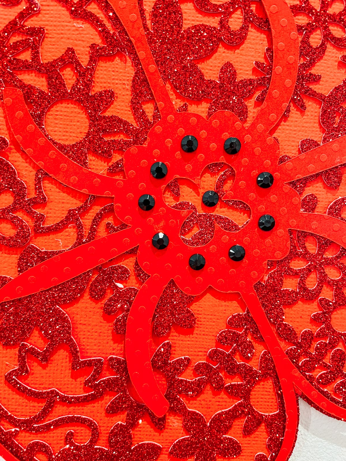Attaching the poppy seeds with black rhinestones